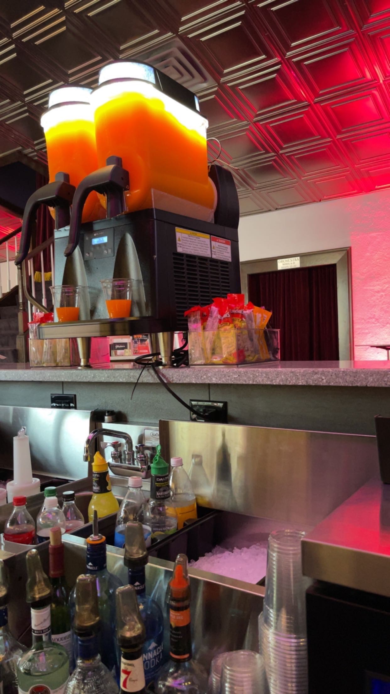 Behind the bar at Titusville Playhouse with red lighting and frozen drinks